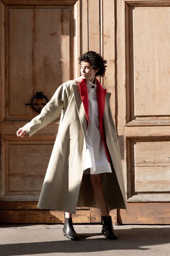 Cut in a luminous beige gabardine, our Essential collection trench coat is an elevated wardrobe staple. With its signature belt, large patch pockets and side slits, it is the perfect piece to pair with our oversized poplin tunic and black satin cigarette pants.
